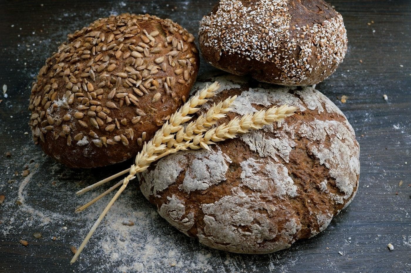 Pains au levain et épis de blé sur une table sombre